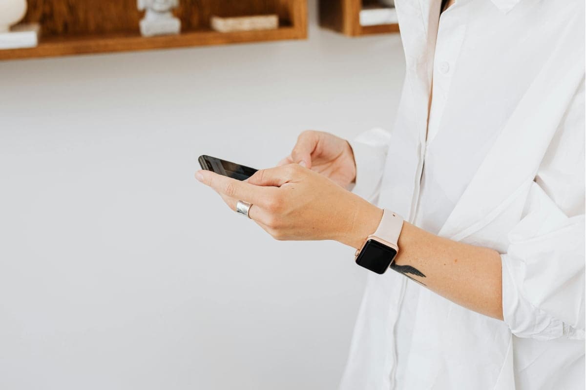 Lash technician checking her mobile phone to find appointment booking software