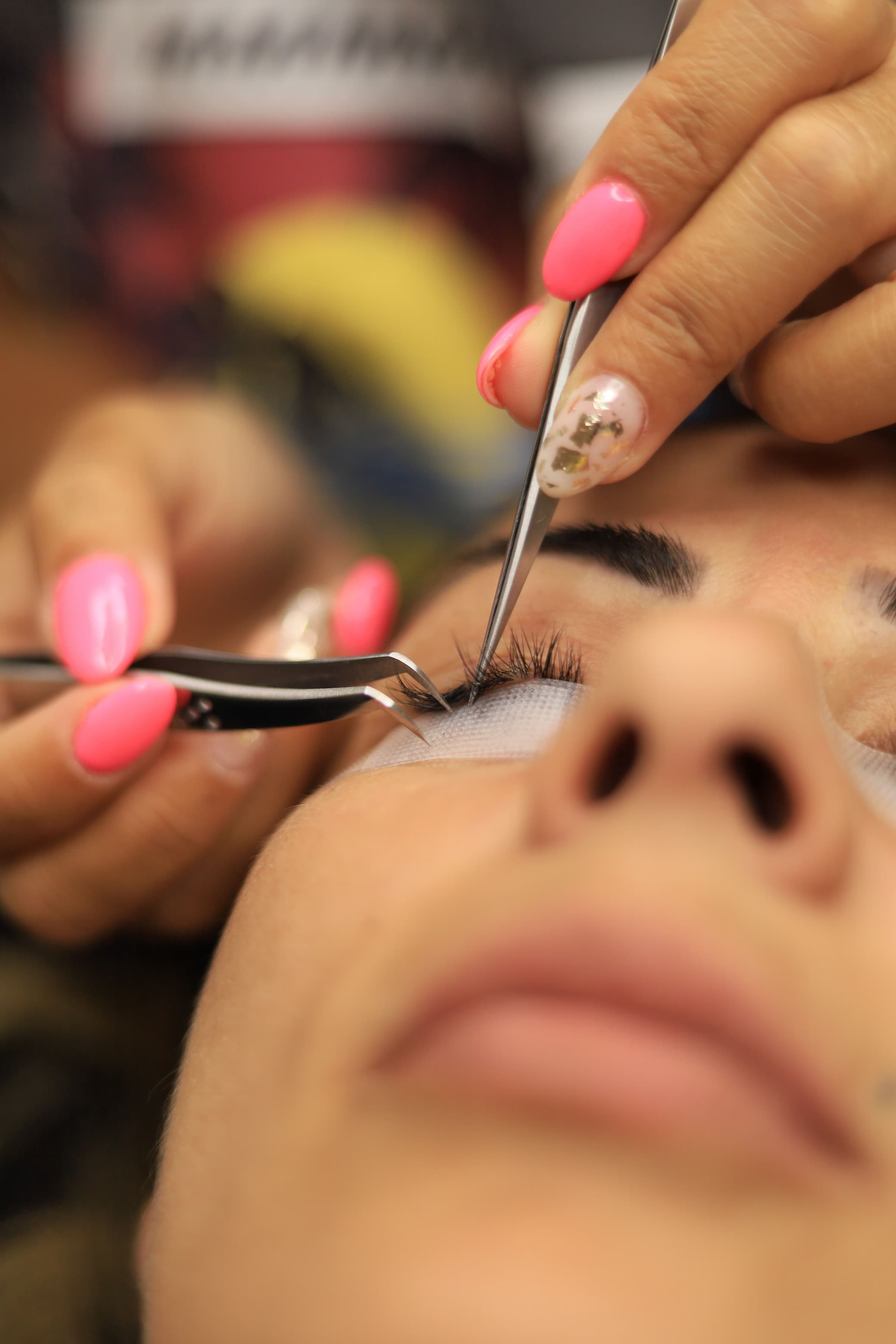 Lash artist finishing a fill for a loyal client who booked a prepaid fill pack