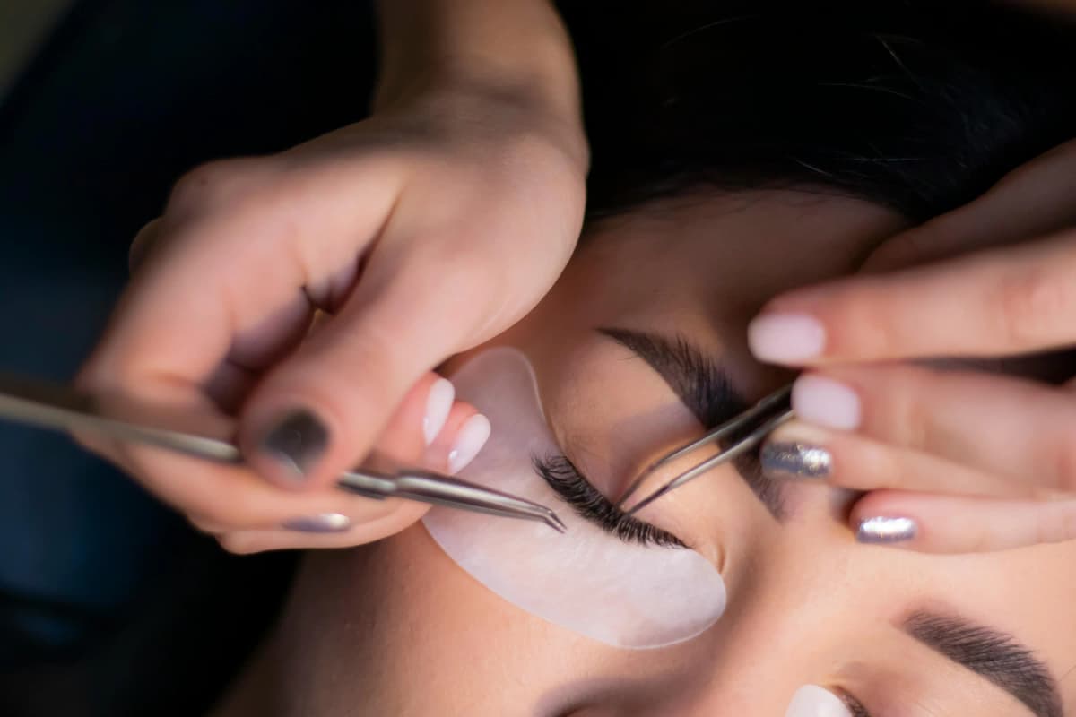 Lash extension treatment appointment Lash artist applying lash extensions during a treatment appointment