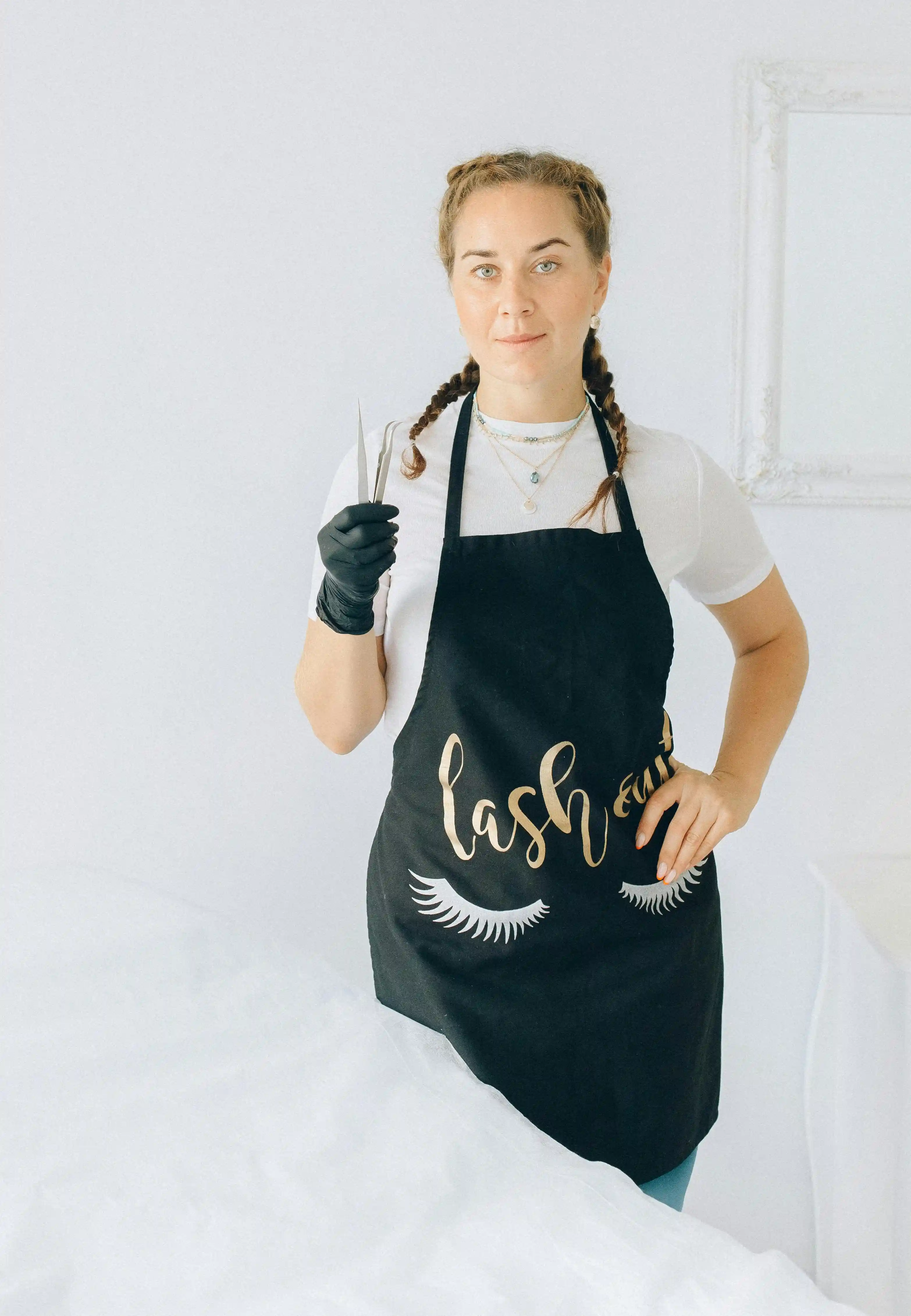 Solo lash artist in studio Solo lash artist standing in a studio holding a lash application tool